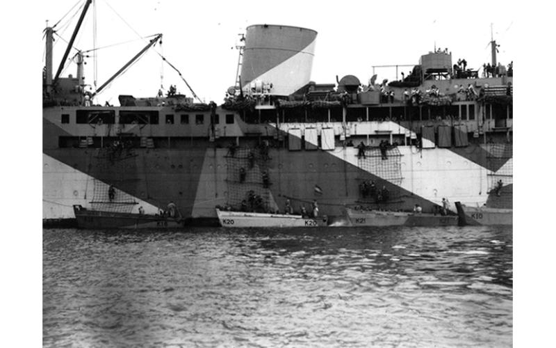 HMAS Kanimbla landing soldiers of the 2/17 Infantry Battalion in Brunei Bay during Operation Oboe Six on 9 June 1945. The troops are descending scrambling nets into the ship’s landing craft.