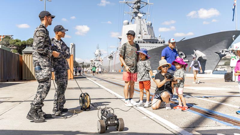 Royal Australian Navy personnel demonstrate to members of the public the operation of an autonomous vehicle