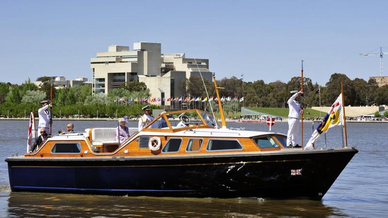 Her Majesty The Queen and The Duke of Edinburgh aboard the Royal Barge as it comes in to dock at Regatta Point near the Floriade site in Canberra.