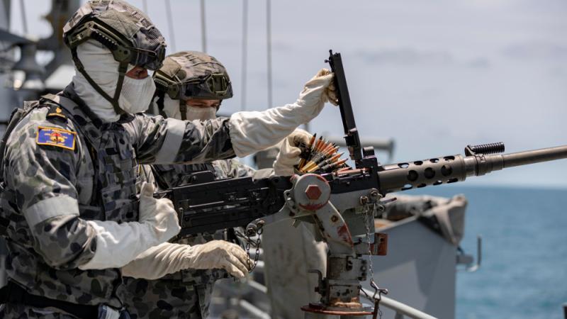 Able Seaman Boatswains Mate Matthew Thompson (left) conducts 12.7mm Browning machine gun drills on HMAS Parramatta.