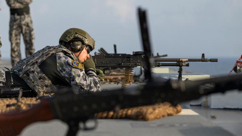 Leading Seaman Boatswains Mate Lukasz Byzdra fires a Mag 58 machine gun on the flight deck of HMAS Adelaide.