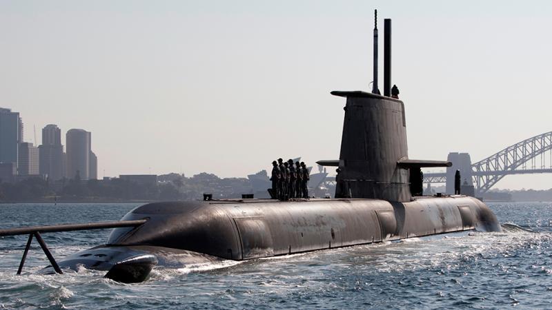 Submarine HMAS Collins rises out of the water in Sydney Harbour.