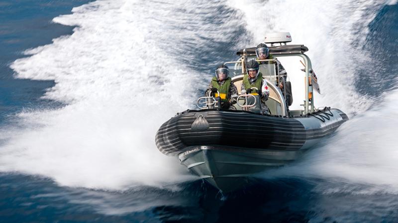 The Rigid Hull Inflatable Boat and crew speeding over the water.